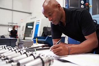 Engineer with pen and machinery